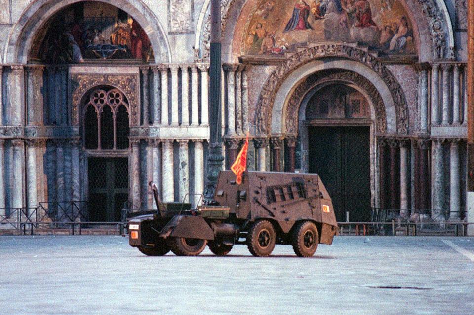 FILE - In this Friday, May 9, 1997 file photo, the mock armored car brought to St. Mark's square by the self-proclaimed Venetian separatists who had occupied the bell tower in the heart of Venice. In background the facade of St. Mark's Basilica. Italian special operations units on Wednesday, April 2, 2014, arrested 24 secessionists who were allegedly planning a violent campaign aimed at making the wealthy northeastern Veneto region independent. Police said in a statement that the group had built an armored vehicle that they intended to deploy in St. Mark's Square in Venice — reminiscent of a 7 ½-hour takeover of the piazza's famed bell tower by secessionists in 1997. TV footage showed the so-called tank was a tractor that had been armed in some fashion. Italian media reported that the secessionists intended to deploy the vehicle on the eve of European Parliamentary elections in May, which will be a measure of growing anti-Europe sentiment arising from harsh austerity measures to fight the economic crisis. (AP Photo/Franco Proietti, File)