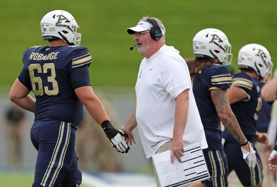 Akron Zips coach Joe Moorhead celebrates with offensive lineman Alex Robarge during the first half Saturday in Akron.