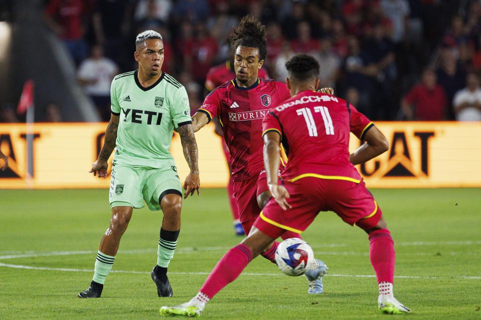 Austin FC midfielder Daniel Pereira, left, passes the ball with St. Louis City SC midfielder Aziel Jackson, center, chasing him during an MLS soccer match in St. Louis, Sunday, Aug. 20, 2023. (Michael Clubb/St. Louis Post-Dispatch via AP)