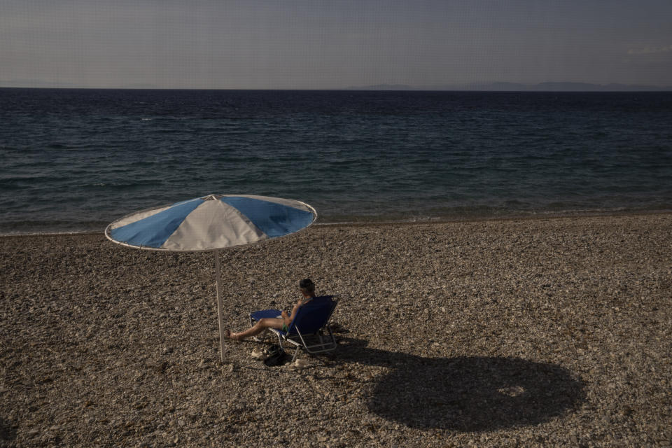 A man sit on a sunbed at a beach in Kokkari , on the eastern Aegean island of Samos, Greece, Tuesday, June 8, 2021. About a month after Greece officially opened to international visitors, the uncertainty of travel during a pandemic is still taking its toll on the country's vital tourist industry. (AP Photo/Petros Giannakouris)