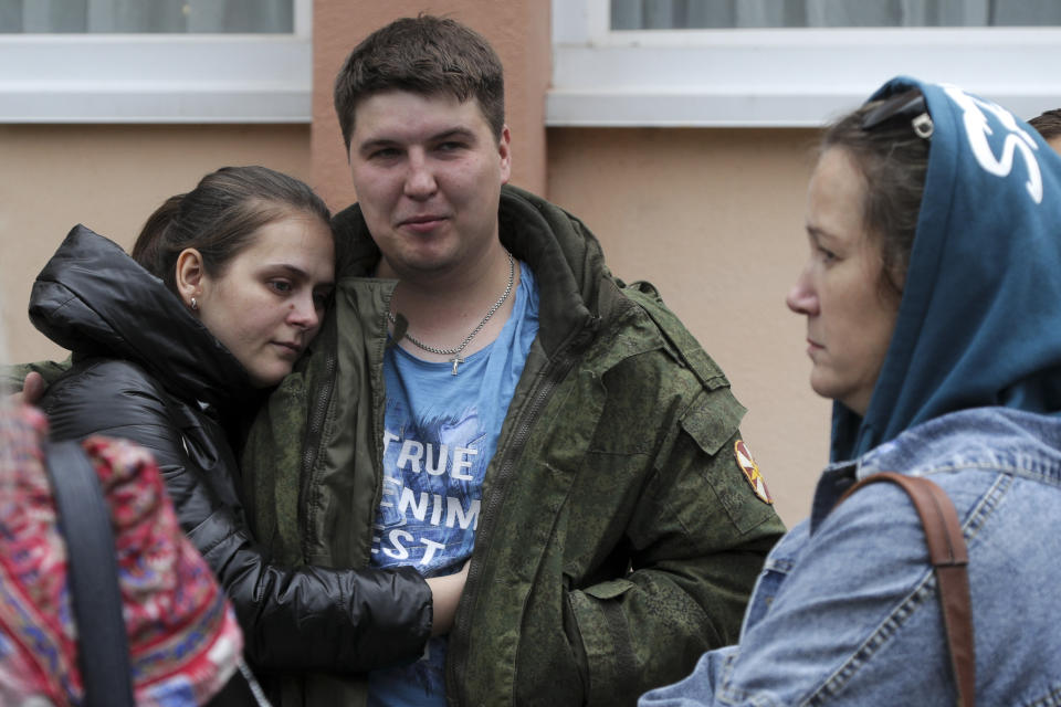 FILE - A Russian recruit and his wife hug outside a military recruitment center in Volzhskiy, Volgograd region, Russia, Sept. 28, 2022. Since Russian President Vladimir Putin announced his mobilization on Sept. 21 for the war in Ukraine, independent media, human rights activists and draftees themselves have painted a bleak picture of a haphazard, chaotic and ethnically biased effort to round up as many men as possible and push them quickly to the front, regardless of skill or training. (AP Photo/File)