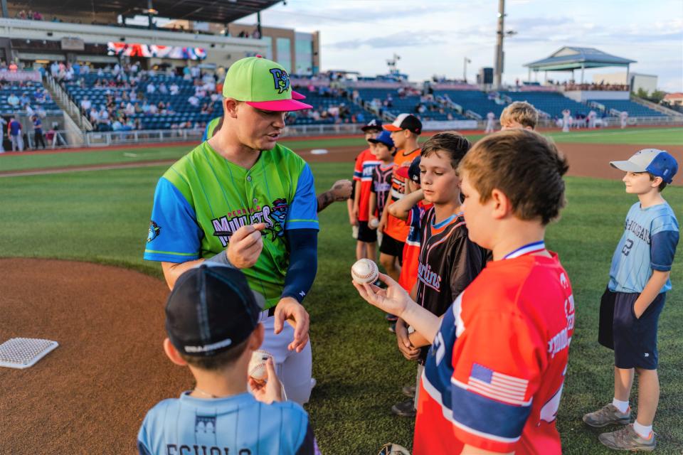 Troy Johnston signs autographs for area kids prior to a recent Blue Wahoos game.