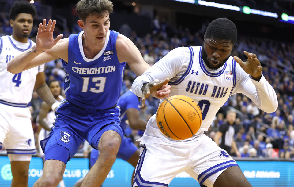 Creighton forward Mason Miller (13) and Seton Hall guard Dylan Addae-Wusu (0) reach for a loose ball during the first half of an NCAA college battle for the ball basketball game in Newark, N.J. Saturday, Jan. 20, 2024. (AP Photo/Noah K. Murray)