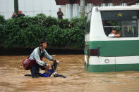 People struggle through floodwaters in Jakarta's central business district on January 17, 2013 in Jakarta, Indonesia. Thousands of Indonesians were displaced and the capital was covered in many key areas in over a meter of water after days of heavy rain. (Photo by Ed Wray/Getty Images)