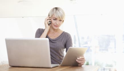 Germany, Bavaria, Munich, Woman working with digital tablet and talking on phone