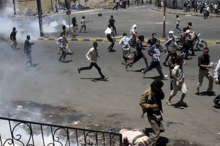 Anti-Houthi protesters seek refuge as pro-Houthi police troopers use tear gas to disperse them in Yemen's southwestern city of Taiz March 25, 2015. REUTERS/Anees Mahyoub