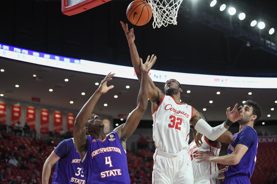 Houston forward Reggie Chaney (32) shoots a layup over Northwestern State center Kendal Coleman (4) during the first half of an NCAA college basketball game Tuesday, Nov. 30, 2021, in Houston. (AP Photo/Justin Rex)