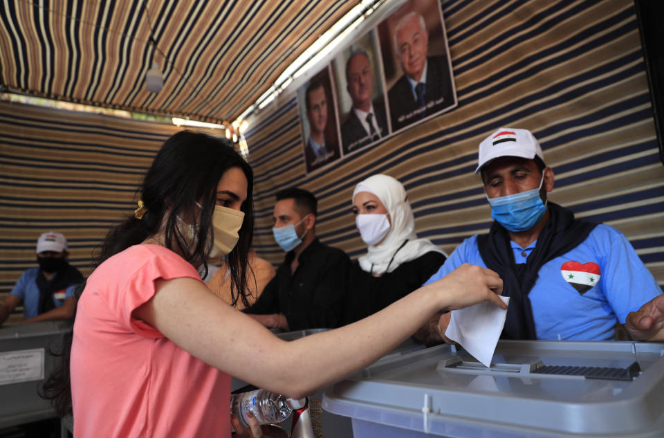 A Syrian woman who lives in Lebanon, casts her ballot for his country's presidential election at the Syrian embassy in Yarze, east of Beirut, Lebanon, Thursday, May 20, 2021. The expat ballot started in embassies abroad ahead of Syria's May 26 presidential election. (AP Photo/Hussein Malla)