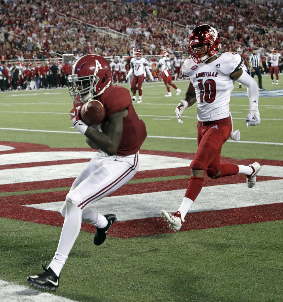 Alabama wide receiver Jerry Jeudy, left, catches a 25-yard touchdown pass in front of Louisville cornerback Rodjay Burns (10) during the first half of an NCAA college football game Saturday, Sept. 1, 2018, in Orlando, Fla. (AP Photo/John Raoux)