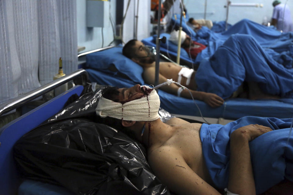 Injured men receive treatment at a hospital after a suicide bombing in Kabul, Afghanistan, Nov. 20, 2018. Afghan officials said the suicide bomber targeted a gathering of Muslim religious scholars. (AP Photo/Rahmat Gul)