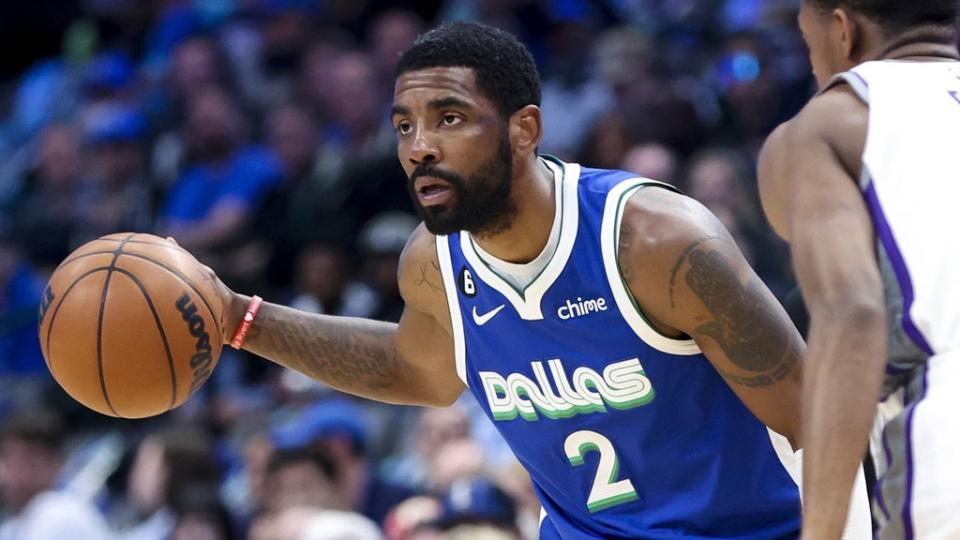 Apr 5, 2023; Dallas, Texas, USA; Dallas Mavericks guard Kyrie Irving (2) controls the ball as Sacramento Kings guard De'Aaron Fox (5) defends during the first quarter at American Airlines Center.