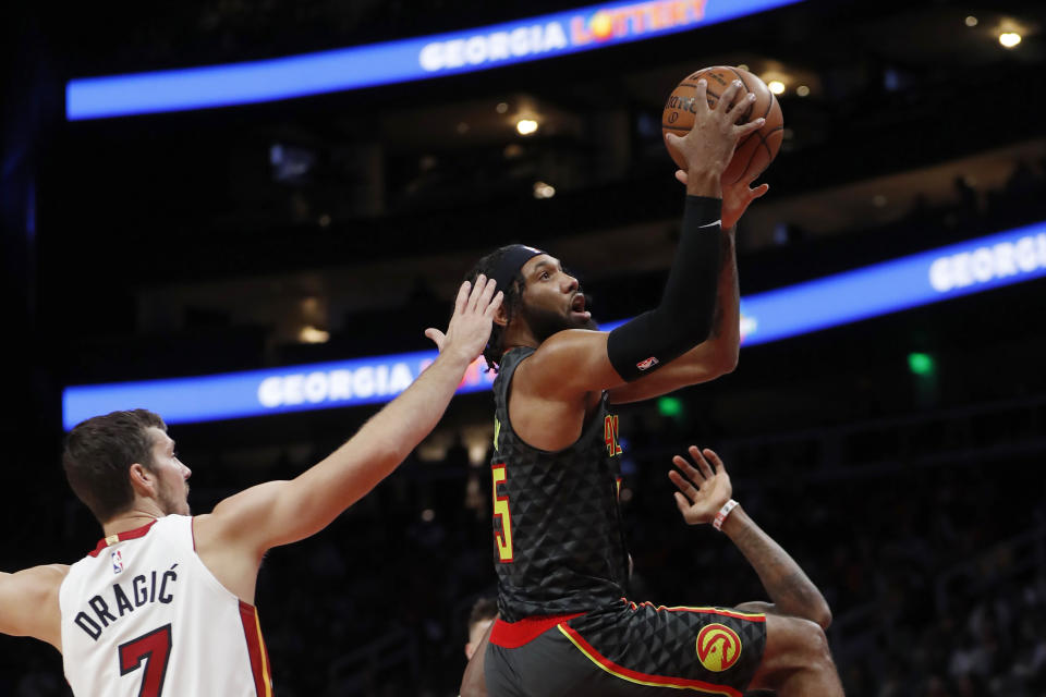 Atlanta Hawks guard DeAndre' Bembry (95) goes in for a shot as Miami Heat guard Goran Dragic (7) defends during the first half of an NBA basketball game Thursday, Oct. 31, 2019, in Atlanta. (AP Photo/John Bazemore)