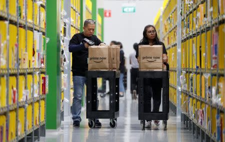 Employees sort out merchandise at Amazon's fulfillment centre ahead of the launch of their Prime Now service in Singapore July 27, 2017. REUTERS/Edgar Su