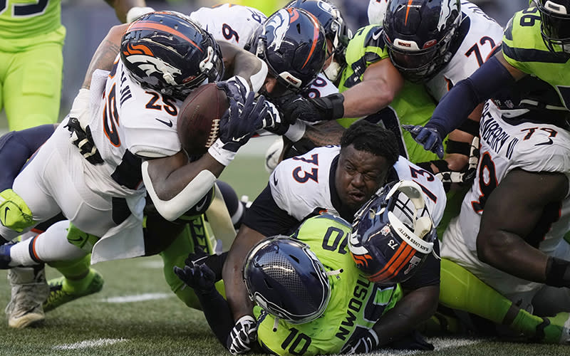 A Denver Broncos player loses his helmet during an NFL football game against the Seattle Seahawks