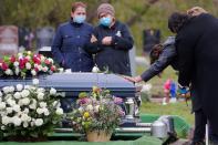 Una mujer se apoya en señal de dolor en el ataúd de su marido, fallecido por coronavirus en Malden, Massachusetts, Estados Unidos. (REUTERS/Brian Snyder)