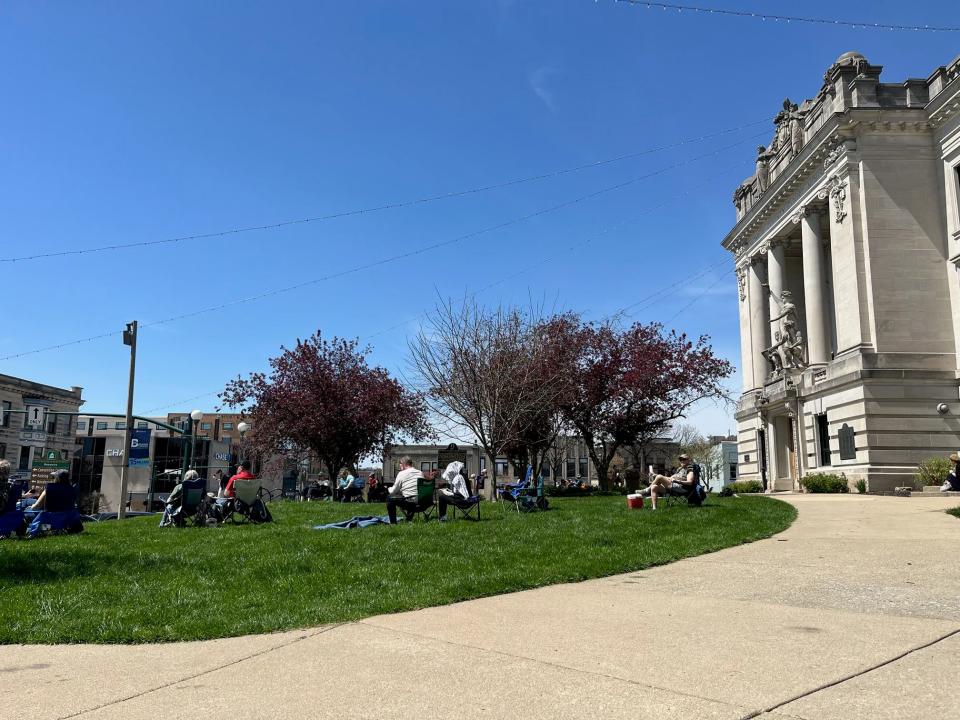 People gather on the Monroe County Courthouse lawn Monday, April 8, 2024, to witness the total solar eclipse.