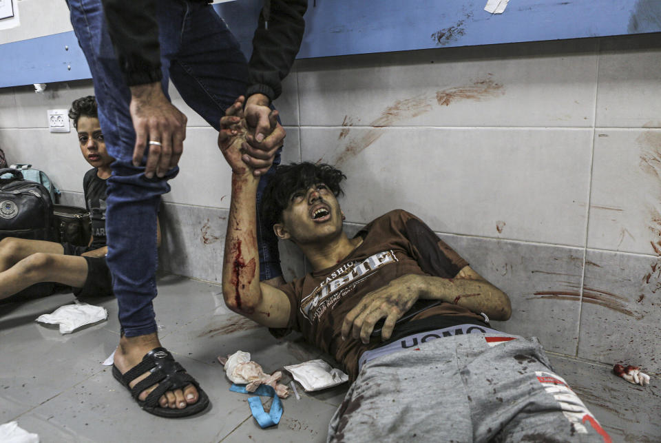 Wounded Palestinians lie on the floor in al-Shifa Hospital in Gaza City, central Gaza Strip, after arriving from al-Ahli Hospital following an explosion there, Tuesday, Oct. 17, 2023. The Hamas-run Health Ministry says an Israeli airstrike caused the explosion that killed hundreds at al-Ahli, but the Israeli military says it was a misfired Palestinian rocket. (AP Photo/Abed Khaled)