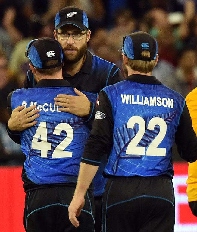 New Zealand's Daniel Vettori (C) hugs team captain Brendon McCullum (L) as Kane Williamson (R) looks on after their defeat against Australia in the Cricket World Cup final in Melbourne on March 29, 2015