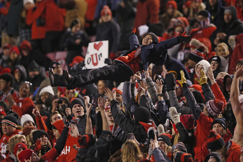 FILE - Utah fans celebrate after scoring against Colorado in the second half during an NCAA college football game Saturday, Nov. 30, 2019, in Salt Lake City. What is most commonly referred to as major college football (aka NCAA Division I Bowl Subdivision or FBS) is compromised of 130 teams and 10 conferences. Seventy-seven of those teams are scheduled to play throughout the fall, starting at various times in September. The other 53, including the entire Big Ten and Pac-12, have postponed their seasons and are hoping to make them up later. That means no No. 2 Ohio State, No. 7 Penn State, No. 9 Oregon and six other teams that were ranked in the preseason AP Top 25.(AP Photo/Rick Bowmer, File)