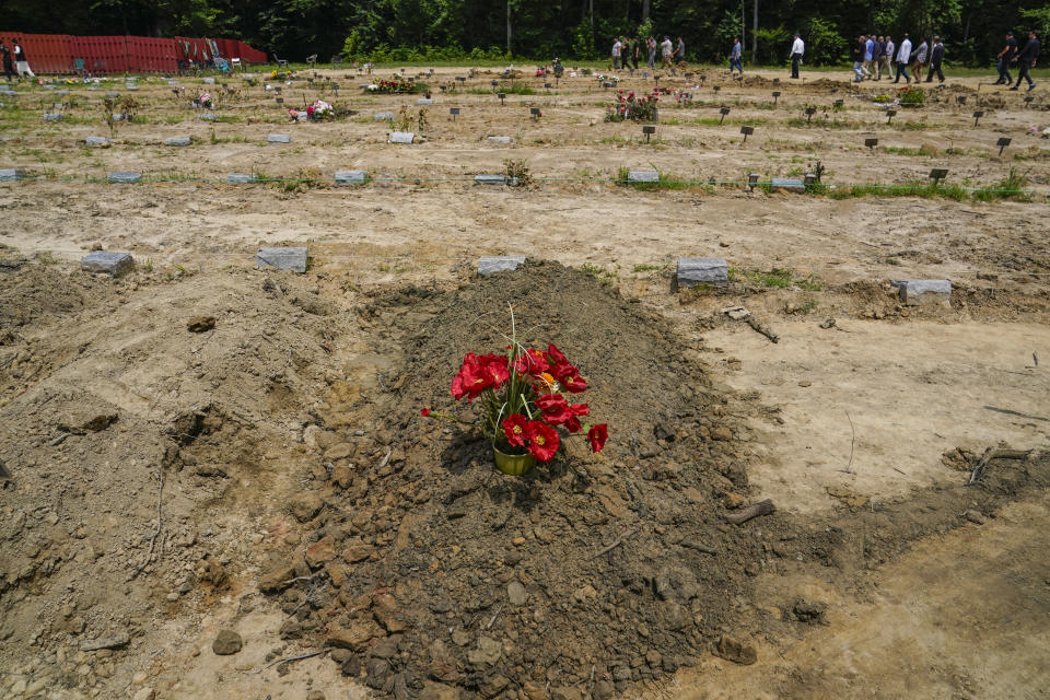 Flowers rest on the grave of Nasrat Ahmad Yar, 31, during a funeral service at the All Muslim Association of America cemetery on Saturday, July 8, 2023, in Fredericksburg, Va. Ahmad Yar, an Afghan immigrant who worked as an interpreter for the U.S. military in Afghanistan, was shot and killed on Monday, July 3, while working as a ride-share driver in Washington. (AP Photo/Nathan Howard)