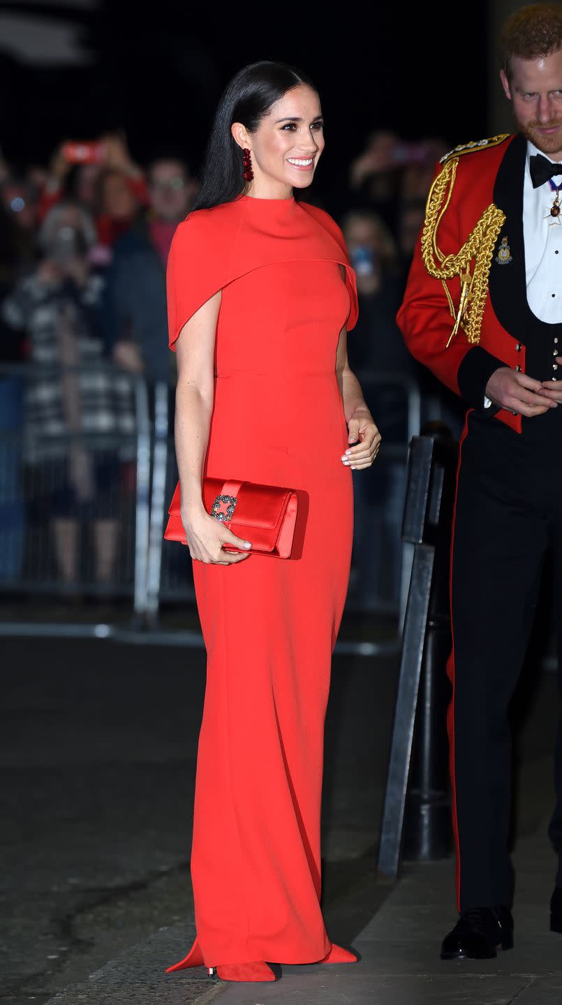 <p>The royal wore a stunning full-length crepe, caped, red dress <a href="https://www.safiyaa.com/products/kalika-long-dress" rel="nofollow noopener" target="_blank" data-ylk="slk:by Safiyaa;elm:context_link;itc:0;sec:content-canvas" class="link ">by Safiyaa</a> for the <a href="https://www.elle.com/uk/life-and-culture/a31269596/meghan-markle-prince-harry-mountbatten-festival-music/" rel="nofollow noopener" target="_blank" data-ylk="slk:event;elm:context_link;itc:0;sec:content-canvas" class="link ">event</a> at London's Royal Albert Hall.</p><p>The former actress wore her hair down, straight, for the event and accessorised with a red clutch bag. </p>