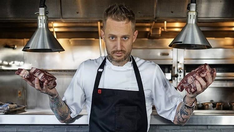 Top Chef winner Michael Voltaggio holding steaks