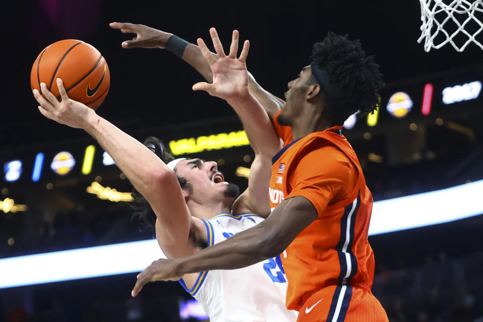 UCLA guard Jaime Jaquez Jr. (24) attempts a shot as Illinois guard Sencire Harris (1) defends during the second half of an NCAA college basketball game Friday, Nov. 18, 2022, in Las Vegas. (AP Photo/Chase Stevens)