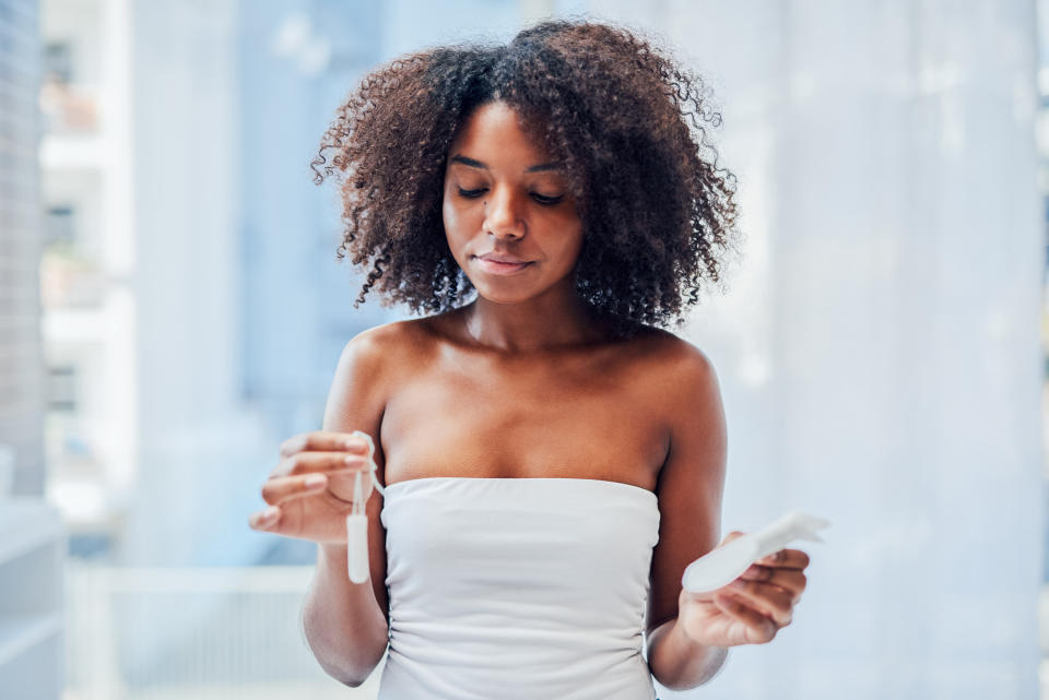 A woman holding a tampon