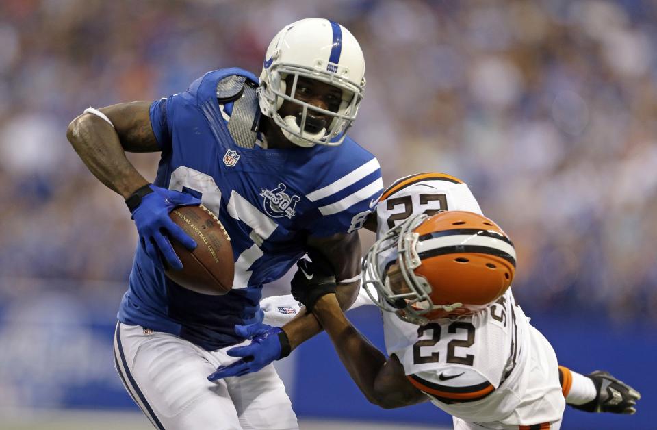 Indianapolis Colts wide receiver Reggie Wayne, left, tries to break away from Cleveland Browns cornerback Buster Skrine during the first half of a preseason NFL football game in Indianapolis, Saturday, Aug. 24, 2013. (AP Photo/Jeff Roberson)