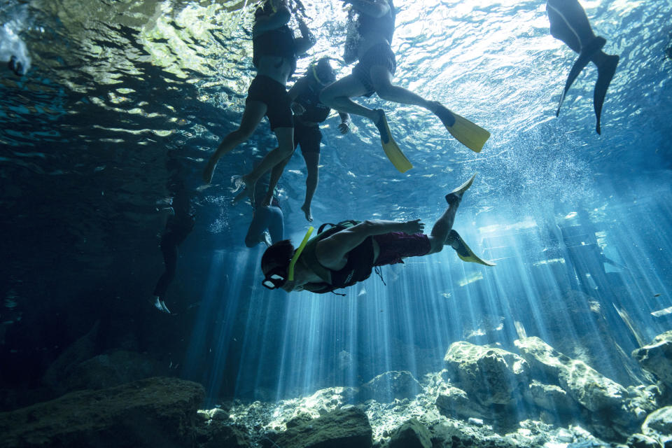 Turistas nadan en el cenote "Dos Ojos", a las afueras de Playa del Carmen, México, el 9 de marzo de 2024. Estos ojos de agua turquesa conocidos como cenotes son parte de una de las maravillas naturales de México: un sistema de aproximadamente 10.000 cavernas, ríos y lagos subterráneos que serpentean bajo la península de Yucatán, en el sureste del país. (AP Foto/Rodrigo Abd)