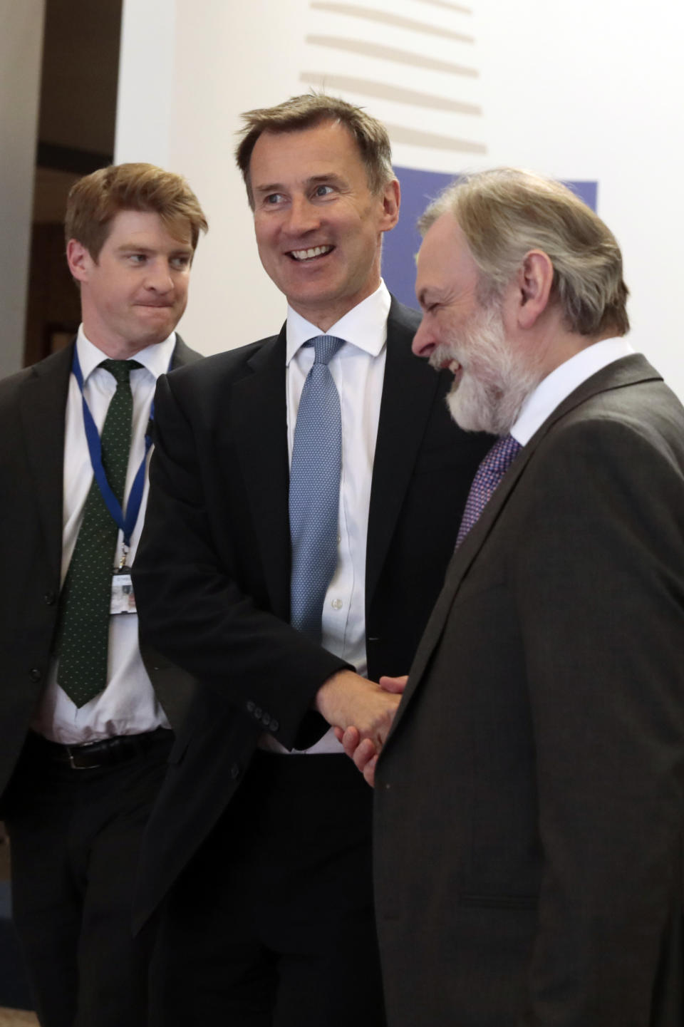 British Foreign Secretary Jeremy Hunt, center, shakes hands with Britain's ambassador to the European Union Tim Barrow, right, after a meeting with European foreign ministers at the Europa building in Brussels, Monday, May 13, 2019. (AP Photo/Virginia Mayo)