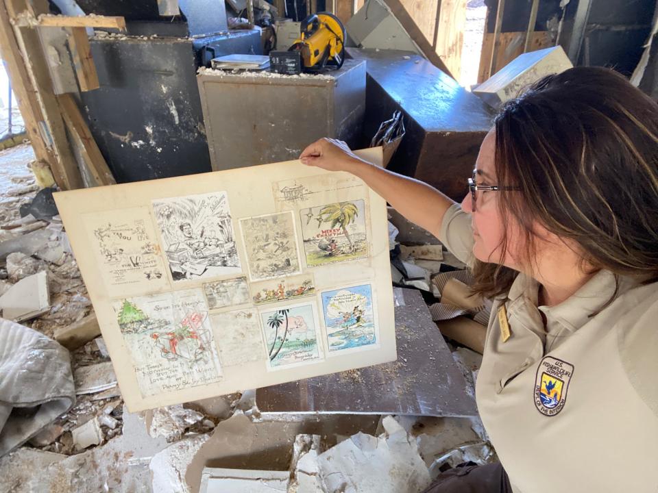 Park ranger Toni Westland holds up a collage of Ding Darling's original drawings which he used to send to friends on the islands as holiday invitations. The drawings were in a frame on the wall of the J.N. Ding Darling Wildlife Society's office, which was destroyed by Hurricane Ian.