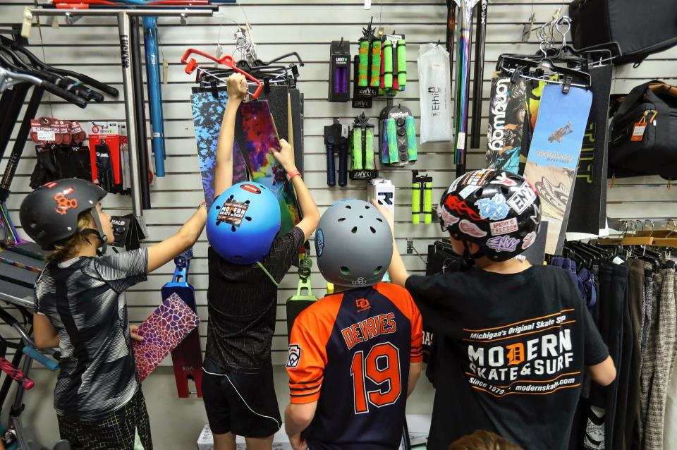 Campers pick out a free deck and accessories for their scooters after completing the skate clinic held at Modern Skate Park on Wednesday, July 12, 2023. 