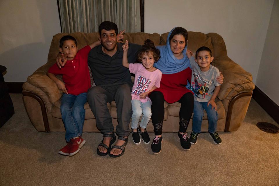 The Azizyar family, from left Roheed, 7, Azizullah, 33, Zainab, 5, Roqia, 29, and Rashid, 4, sit on a couch donated to them in their rental house in Mechanicsburg, Pennsylvania, where they were resettled after a harrowing escape from Afghanistan, where the Taliban were hunting down commandos like Azizullah.