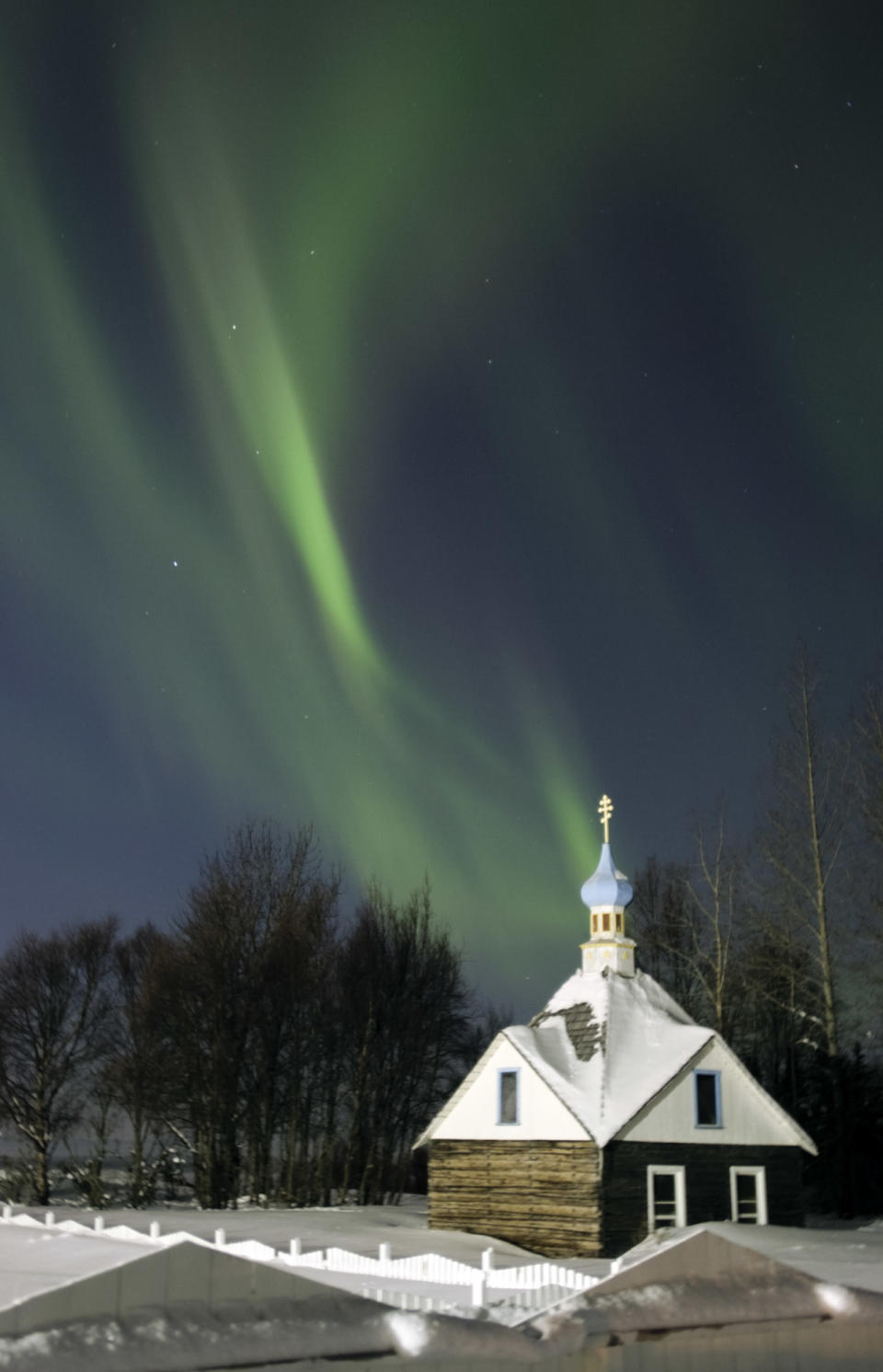 Vista de la capilla de la iglesia ortodoxa San Nicolás en Kenai, Alaska, el 9 de marzo de 2012, con la aurora boreal de fondo. AP Photo/Peninsula Clarion, M. Scott Moon