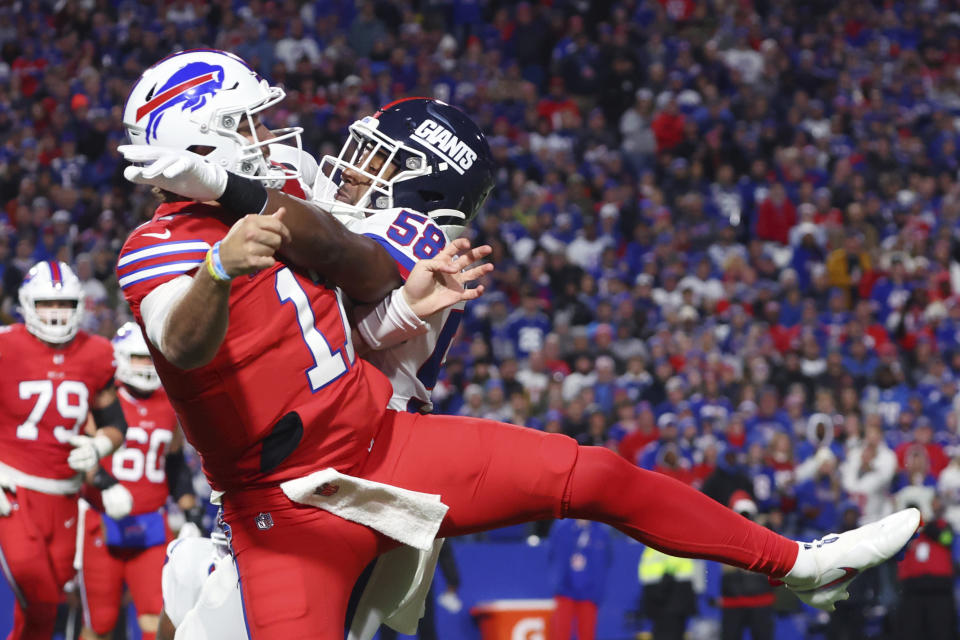 Buffalo Bills quarterback Josh Allen, left, gets hit by New York Giants linebacker Bobby Okereke during the first half of an NFL football game in Orchard Park, N.Y., Sunday Oct. 15, 2023. (AP Photo/ Jeffrey T. Barnes)