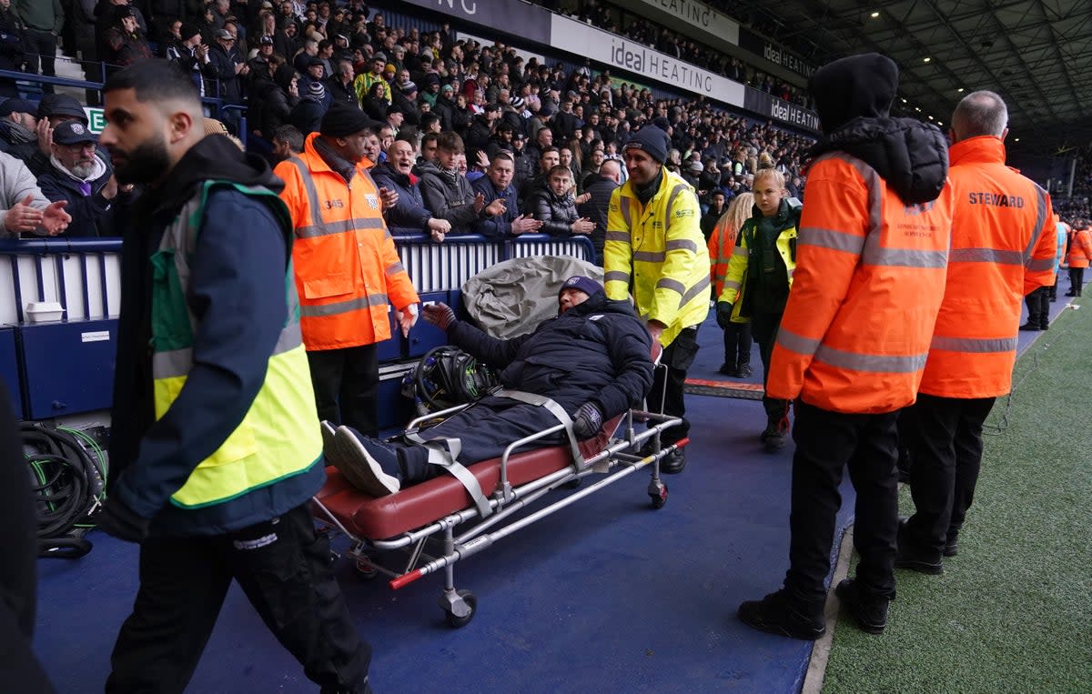 A West Bromwich Albion is stretched out of the ground following clashes in the stands during the Emirates FA Cup fourth round match at The Hawthorns (Bradley Collyer/PA Wire)