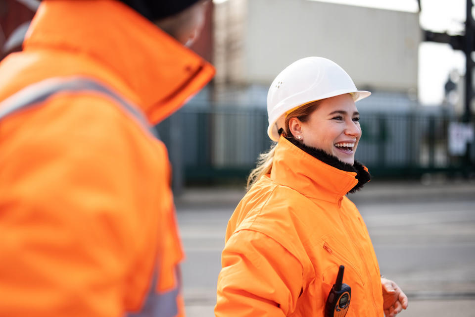 Two engineer smiling while talking at the shipyard