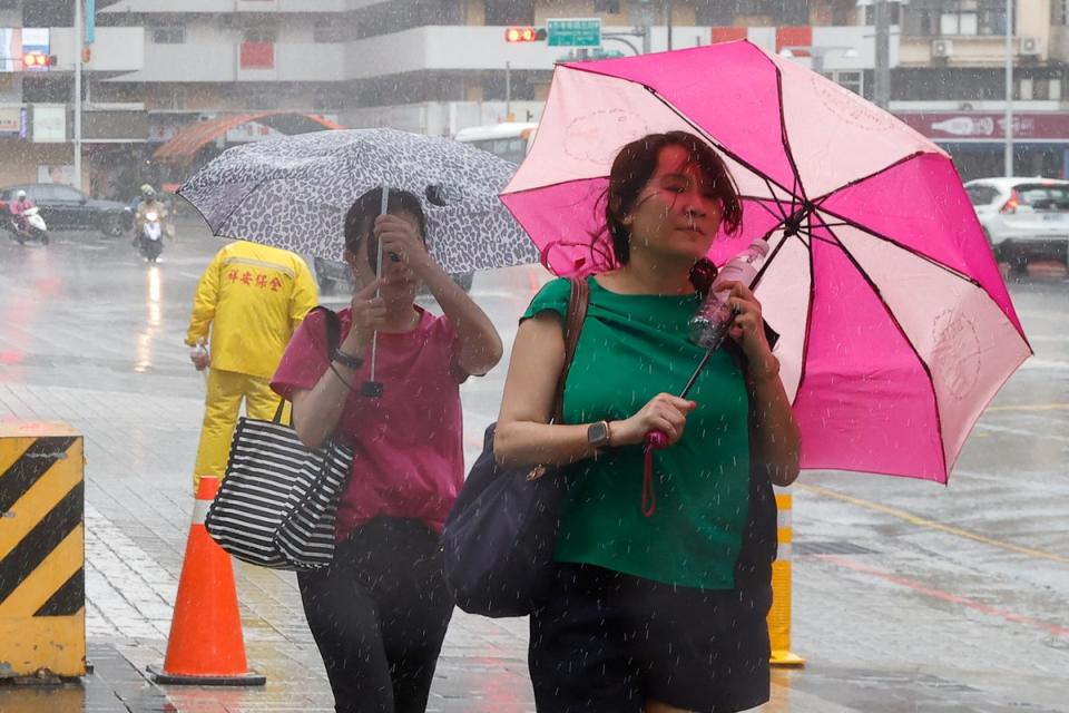 People walk with umbrellas in Taipei as Typhoon Haikui approaches (REUTERS)