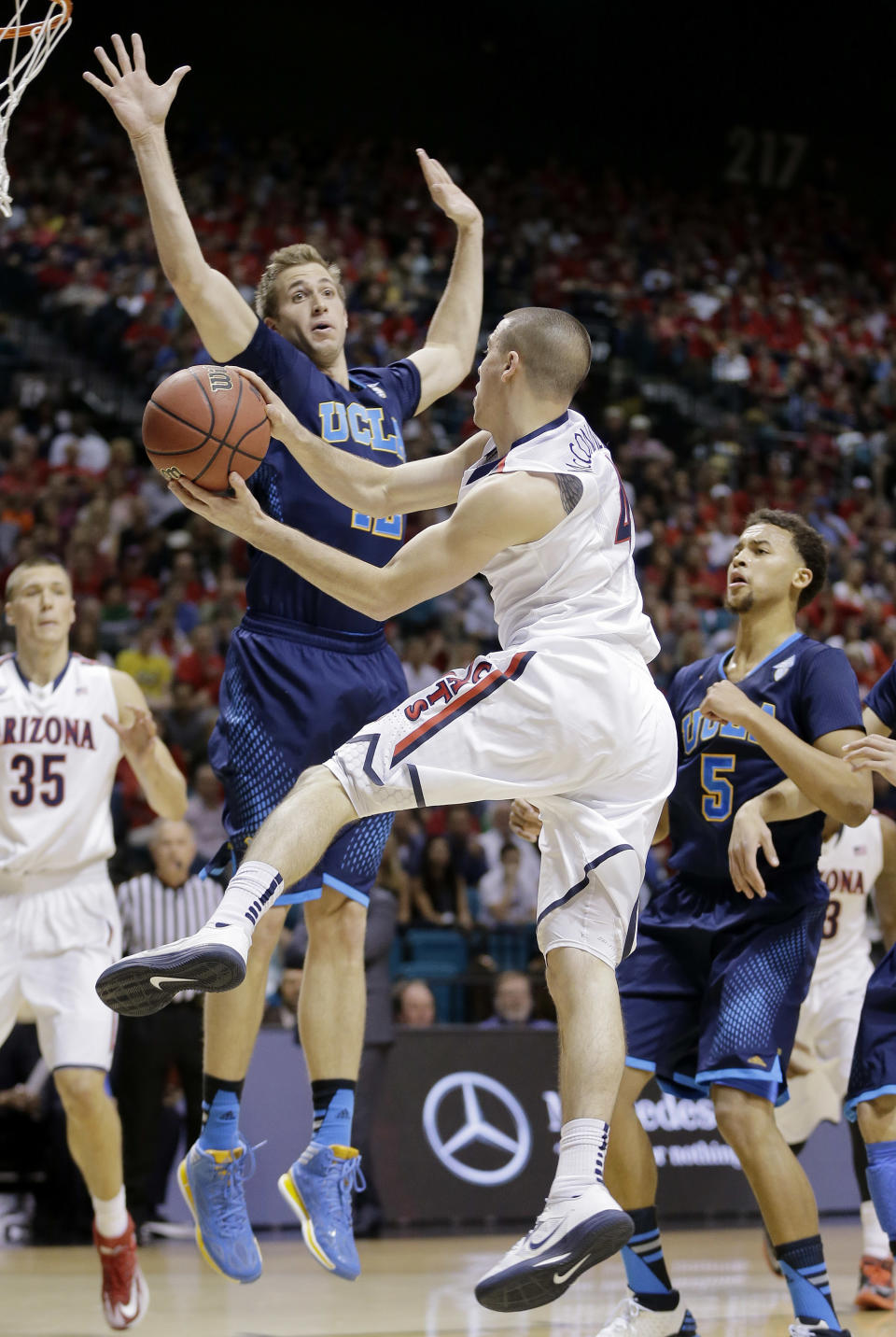 Arizona's T.J. McConnell passes off the ball against UCLA's David Wear in the first half during the championship game of the NCAA Pac-12 conference college basketball tournament, Saturday, March 15, 2014, in Las Vegas. (AP Photo/Julie Jacobson)