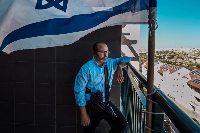 KIRYAT ARBA, OCCUPIED WEST BANK -- NOVEMBER 9, 2023: Tzvika Mor speaks on a phone interview with a radio station, at his home in Kiryat Arba, an Israeli settlement that neighbors Hebron in the occupied West Bank, Thursday, Nov. 9, 2023. MorOs 23-year-old son Eitan, a security guard at the Supernova desert party outside Gaza, is one of HamasO kidnapped hostages after the groupOs unprecedented assault on Oct 7. on Israeli communities surrounding Gaza killing 1200 Israelis and capturing more than 240 hostages. On a public television interview, Tzvika Mor quoted the Rambam D saying that during war, a person must not weaken his battle resolve with thoughts of his loved ones D wife and children D and said that even though he loves his son, his country comes first. OWe have been called to the flag, we must be ready for sacrifices,O Mor said. (MARCUS YAM / LOS ANGELES TIMES)