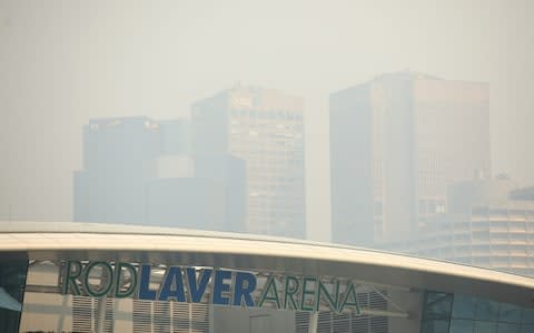 A general view of Rod Laver Arena with the city shrouded in smoke in the background ahead of the 2020 Australian Open  - Credit: Getty