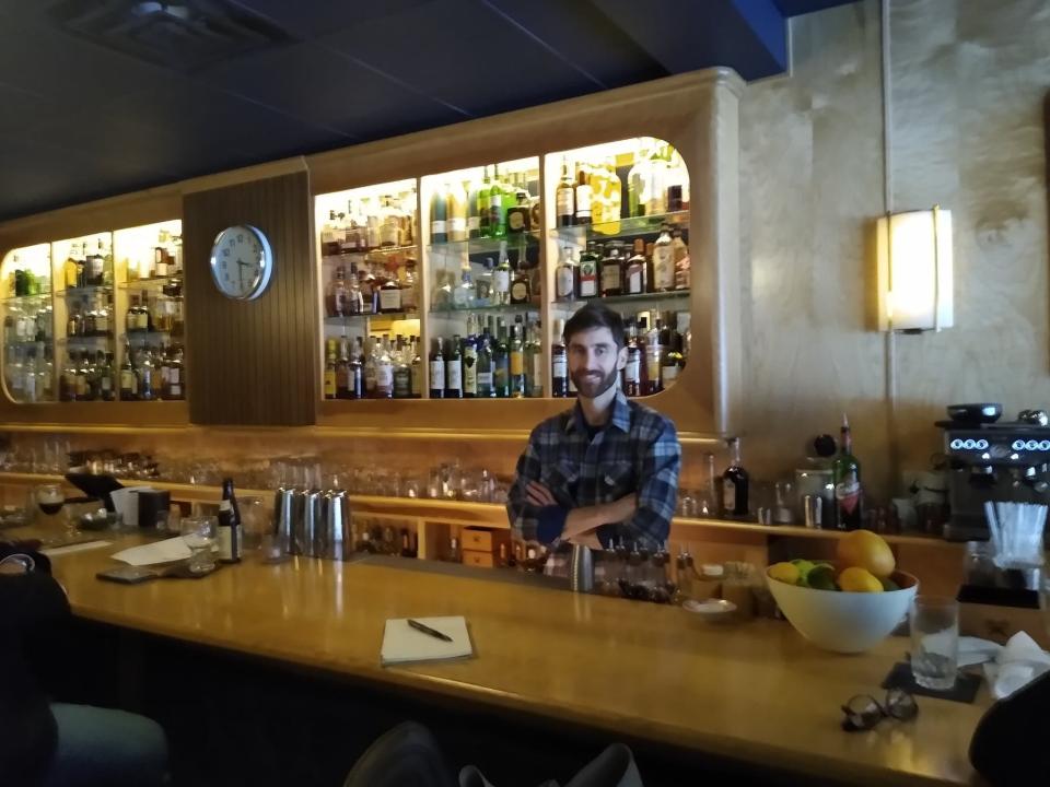 Owner David Murrin von-Eber stands behind the bar in The Bartender's Handshake