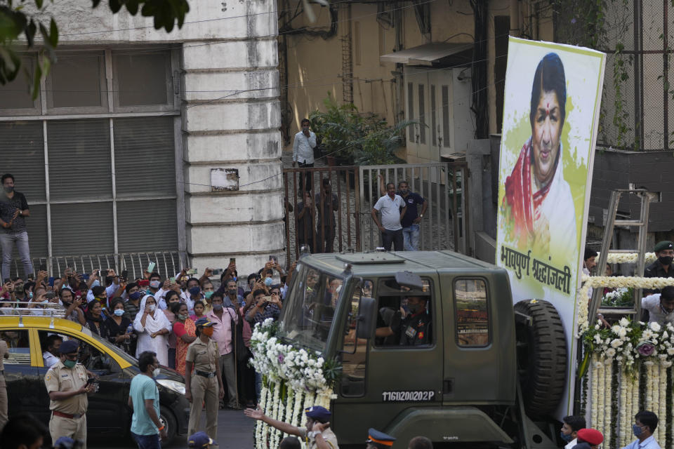 The body of Lata Mangeshkar, is taken for funeral procession outside her house in Mumbai, India, Sunday, Feb.6, 2022. The legendary Indian singer with a prolific, groundbreaking catalog and a voice recognized by a billion people in South Asia, died Sunday morning of multiple organ failure. She was 92. (AP Photo/Rafiq Maqbool)