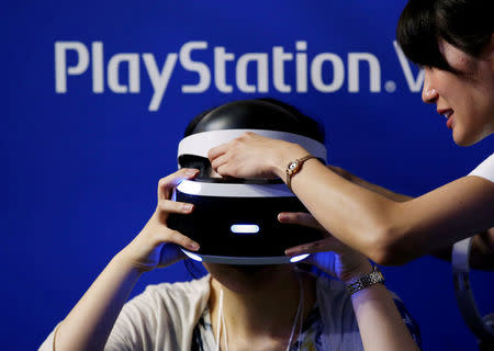 A hostess helps a woman to wear Sony's PlayStation VR headset at Tokyo Game Show 2016 in Chiba, east of Tokyo, Japan, September 15, 2016. REUTERS/Kim Kyung-Hoon/File Photo