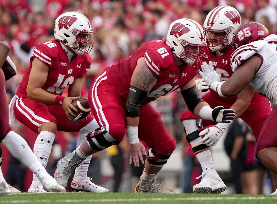 Wisconsin offensive lineman Dylan Barrett (61) snaps the ball to quarterback Myles Burkett (16) during the fourth quarter of their game Saturday, September 17, 2022 at Camp Randall Stadium in Madison, Wis. Wisconsin beat New Mexico State 66-7.