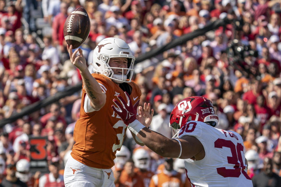 Texas quarterback Quinn Ewers (3) pitches the ball forward as he is pressured by Oklahoma defensive lineman Trace Ford (30) during the first half of an NCAA college football game at the Cotton Bowl, Saturday, Oct. 7, 2023, in Dallas. (AP Photo/Jeffrey McWhorter)