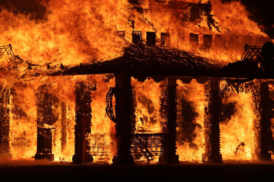 The "Temple of Time" built as a memorial to the 17 victims of a shooting at Marjory Stoneman Douglas High School is seen on fire during a ceremonial burning in Coral Springs, Fla., Sunday, May 19, 2019. The "Temple of Time" public art installation was set on fire Sunday at the ceremony hosted by the cities of Parkland and Coral Springs, where the high school's students live. (John McCall/South Florida Sun-Sentinel via AP)
