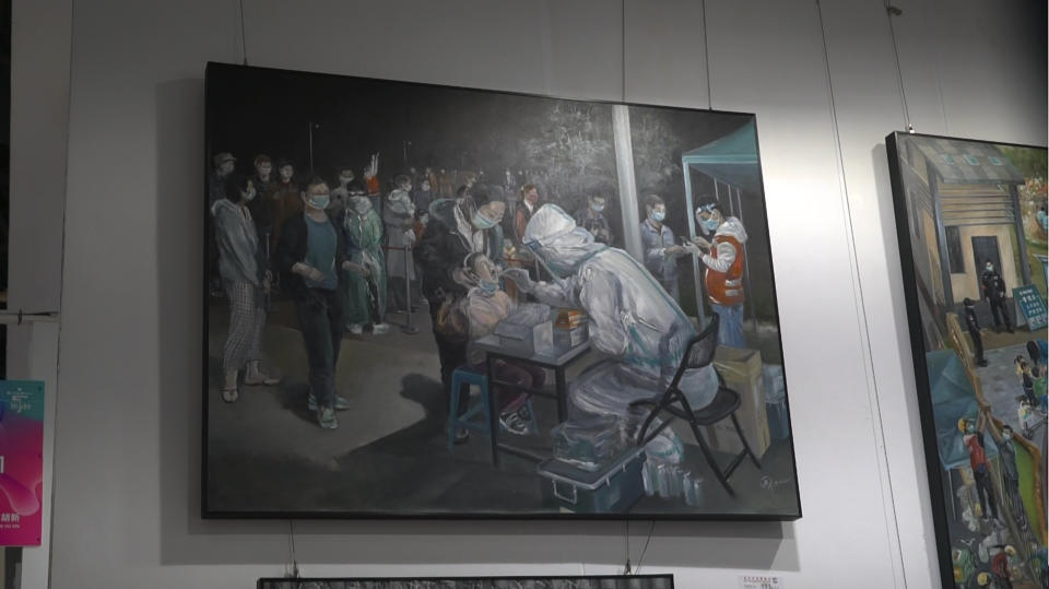 An art work depicting a Covid testing scene by Zeng Fanzhi, an retired architect turned artist, is seen at the Beijing art exposition in Beijing, Friday, Sept. 8, 2023. Zeng painted stark, realist portrayals of life in China under zero-COVID, saying he did so to capture a unique moment in history. (AP Photo/Dake Kang)