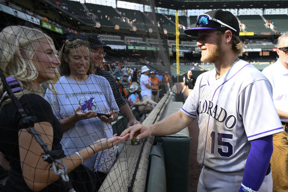Colorado Rockies' Hunter Goodman, right, meets with his fiancee Sydney McClain, left, after a baseball game against the Baltimore Orioles, Sunday, Aug. 27, 2023, in Baltimore. The Rockies won 4-3. (AP Photo/Nick Wass)